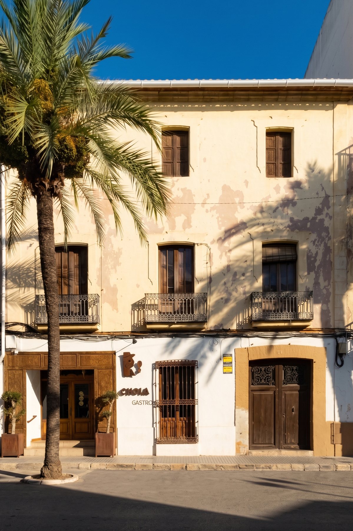 Heritage 13 on Avenida d'Alacant: historic façade with wrought-iron balconies and a palm tree.